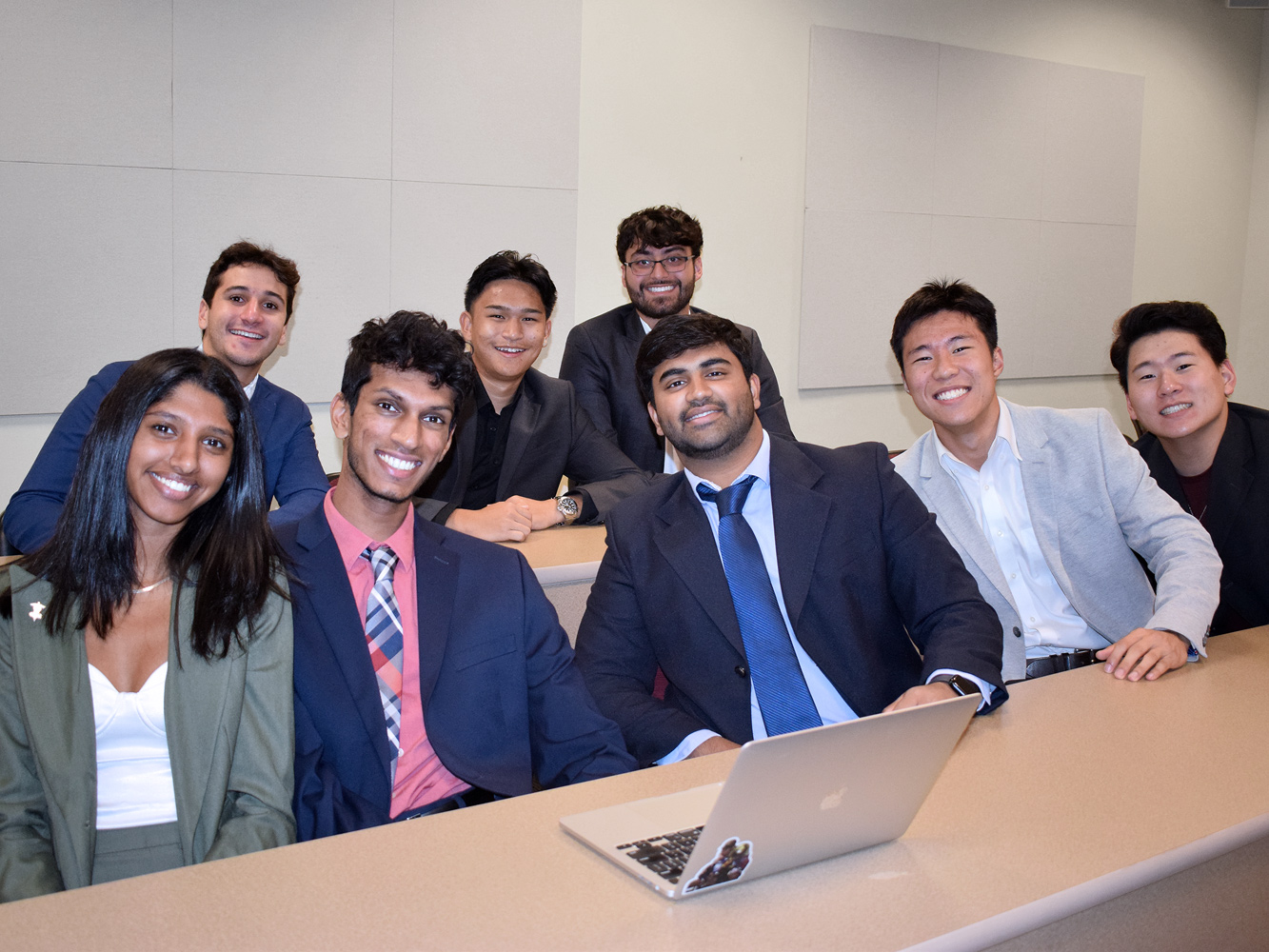 A diverse group of HPAO students dressed in formal business attire, in a conference room.